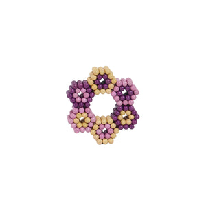 Speks magnetic balls arranged in hexagonal flower pattern with purple, pink, and natural wood colored spheres